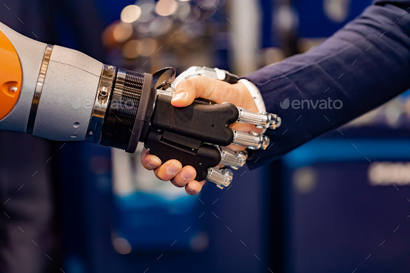 Hand of a businessman shaking hands with a Android robot. - Stock Photo - Images