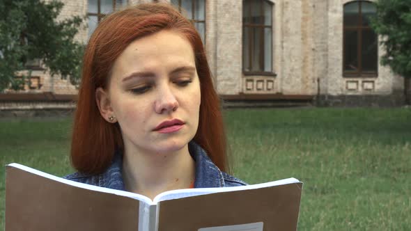 Girl Reading and Smiling at Camera alt