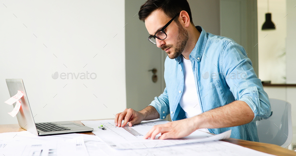 Architect working on plans at home office table