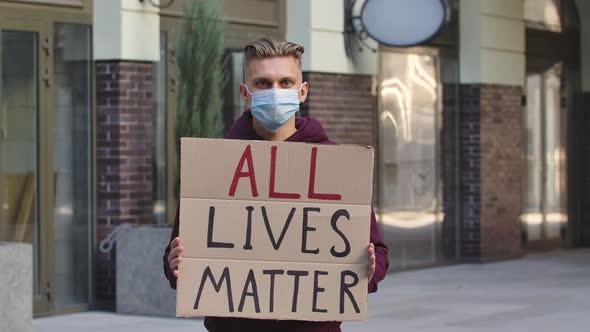 ALL LIVES MATTER Concept, No Racism. Outdoors Portrait of a Young Male Activist Wearing a Medical alt