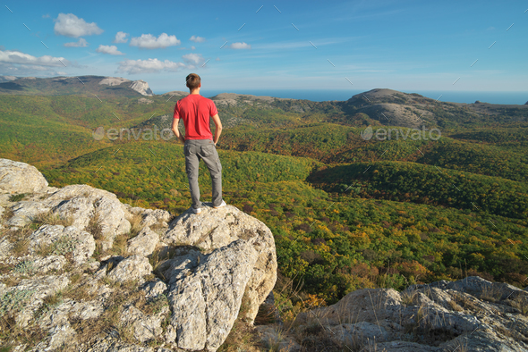 Man standing on the edge of cliff mountain.