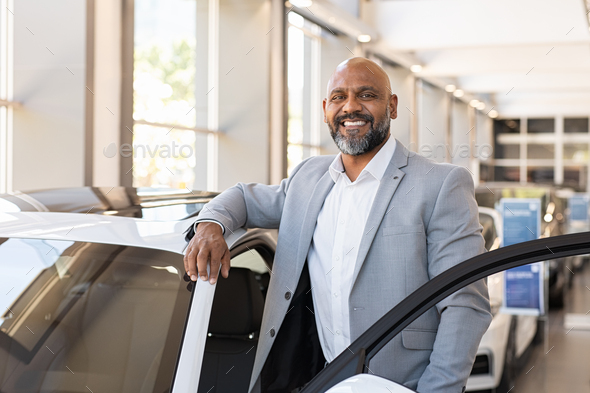 Happy mature black man at car dealership