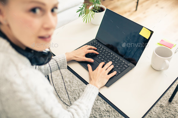 Woman working from home on laptop computer - Stock Photo - Images