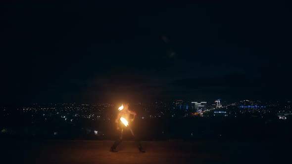 Clip Begins with Nobody in Sight. Camera Captures Young Man Doing Fire Dance with Two Torches alt