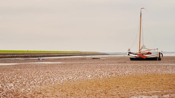 sailing boat dry on tidal mud flat Wadden Sea Netherlands timelapse ZOOM IN alt