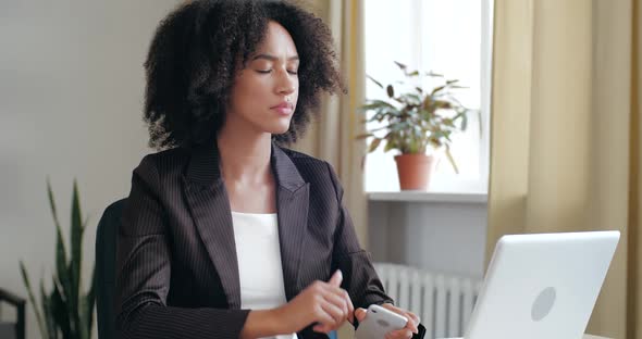 Attractive Girl Sits at Table, Surf the Internet, Uses Phone To Communicate and Solve Problems alt