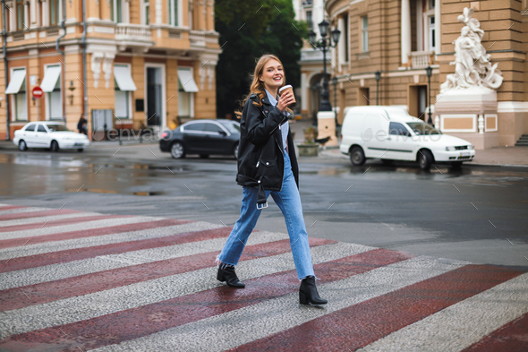 Young smiling woman in leather jacket and jeans joyfully looking - Stock Photo - Images
