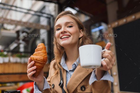 Portrait of beautiful smiling girl in trench coat happily lookin - Stock Photo - Images