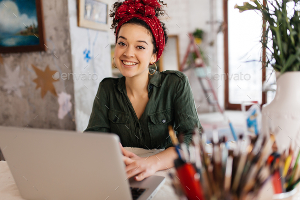 Young attractive woman with dark curly hair sitting at the table - Stock Photo - Images