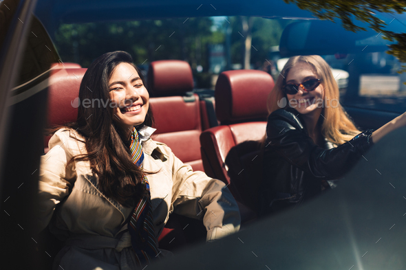 Two cheerful girls happily spending time together driving cabrio - Stock Photo - Images
