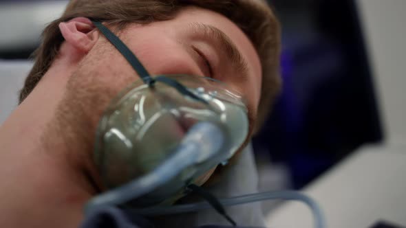 Unconscious Man Breathing in Oxygen Mask alt