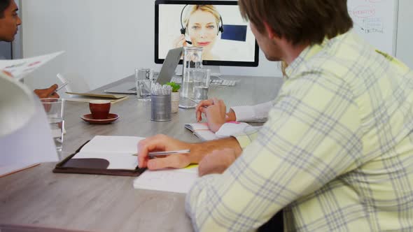 Business executives discussing while having video call on computer  alt