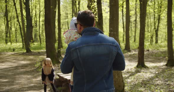 Little Happy Girl And Father With A Child In Their Arms Spend Time In Nature alt