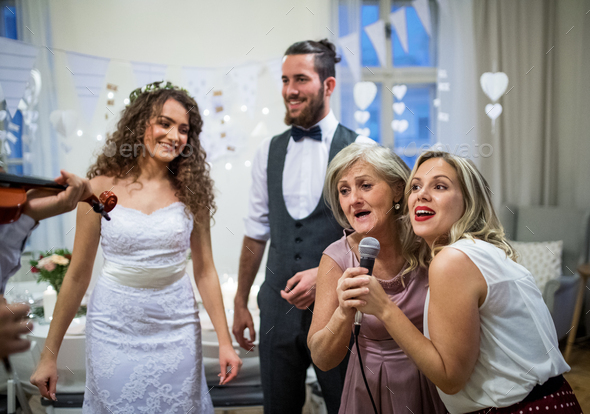 A Young Bride And Groom With Other Guests Dancing And Singing On A