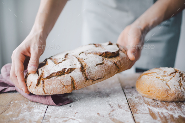 Baker or chef holding fresh made bread - Stock Photo - Images