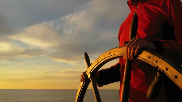 Man Holding Ship Rudder and Steers in Sunset Light.