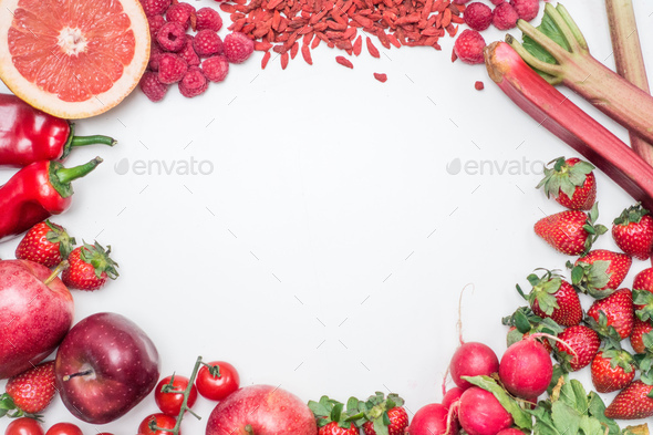 Aerial vibrant shot of red fruit and vegetables on a white background