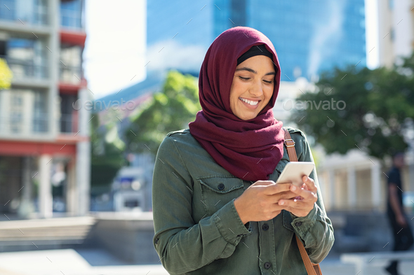 Islamic woman in hijab using phone - Stock Photo - Images