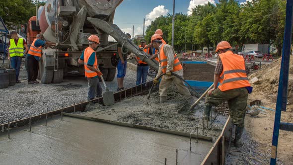 Concrete Works for Road Construction with Many Workers and Mixer Timelapse alt