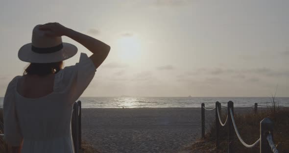 Attractive girl in a hat by the sea, slow motion alt