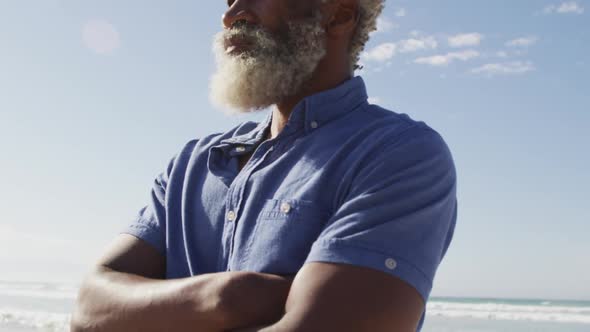 Senior african american man looking away on sunny beach alt