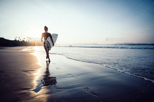 Surfer  with surfboard on beach - Stock Photo - Images