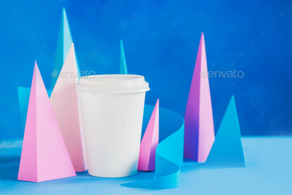 Modern coffee header. Blank paper cup on an abstract background with modern paper sculpture. Paper
