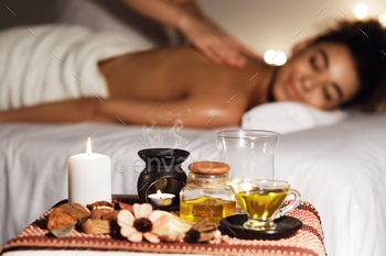 African woman enjoying aromatherapy massage in luxury spa