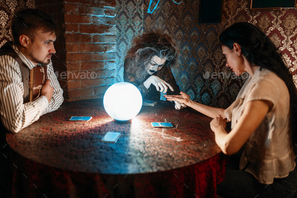 Foreteller guessing by hand over a crystal ball - Stock Photo - Images
