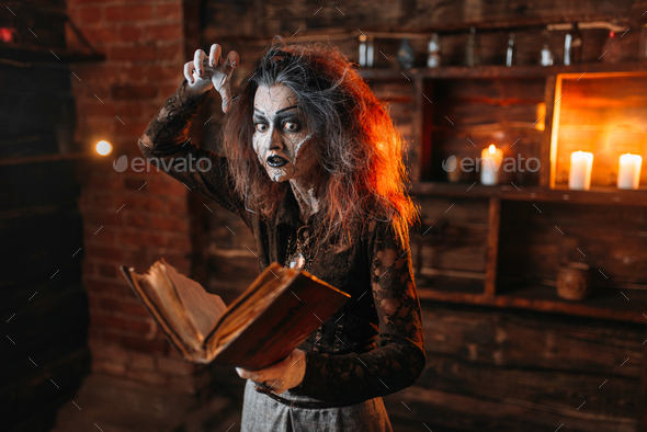 Witch holds spellbook, dark powers of witchcraft - Stock Photo - Images