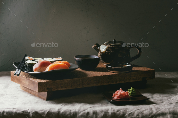 Sushi Set nigiri and sushi rolls on wooden serving board with soy