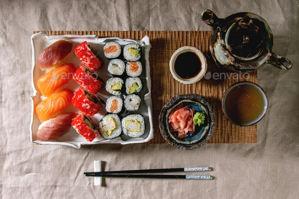 Sushi Set nigiri and sushi rolls on wooden serving board with soy