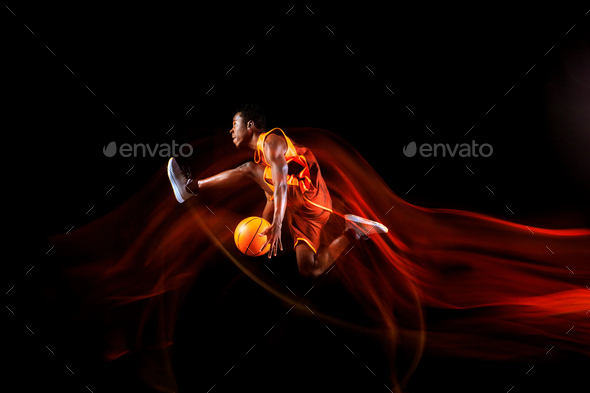Young basketball player against dark background - Stock Photo - Images