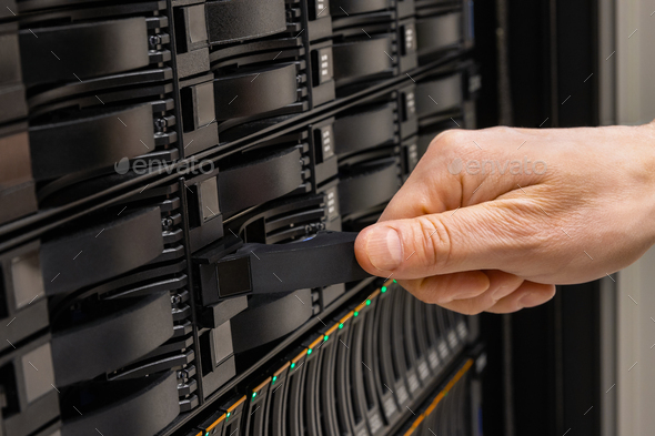 Male IT Engineer Replacing SAN Server Drive From Rack Stock Photo by kjekol