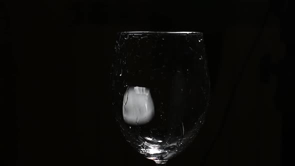 Adding Ice Cubes Into Glass Against Dark Background
