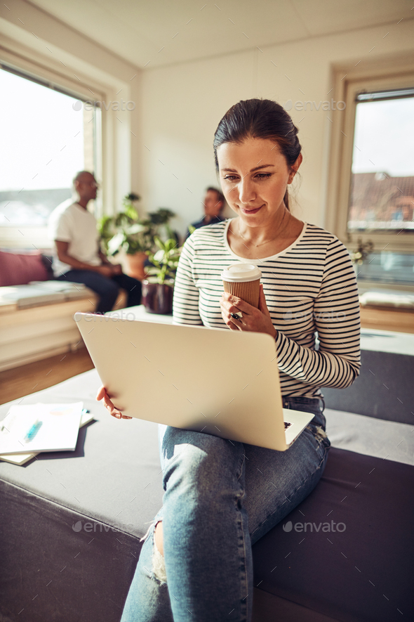 Businesswoman working online and enjoying a coffee on her break - Stock Photo - Images