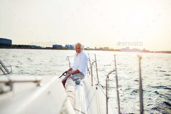 Mature man sailing his boat on the open water