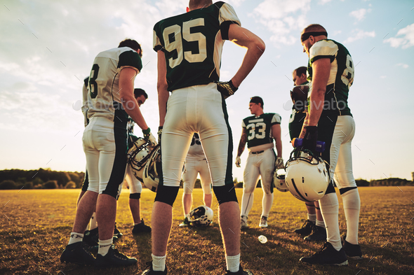 American football players standing in a circle during practice