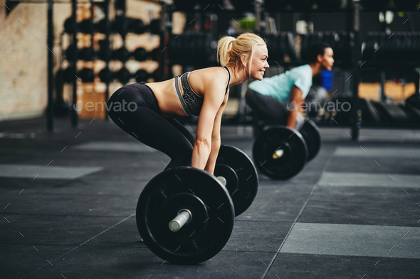 Fit young woman lifting weights during a gym class