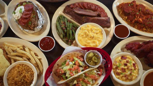 Top down tabletop view of assorted barbecue and Texas comfort food menu items, slider 4K alt