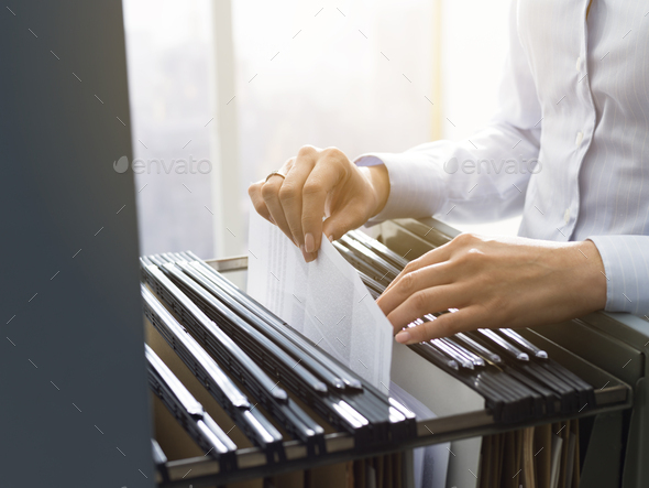 Office clerk searching files in the filing cabinet