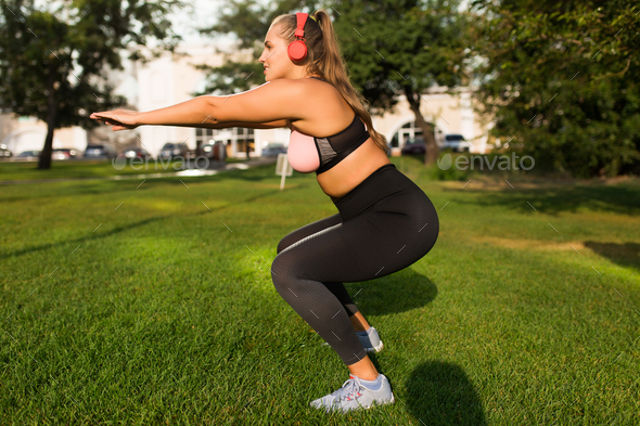 Young attractive plus size woman in sporty top and leggings with - Stock Photo - Images