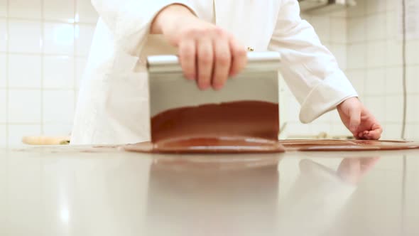 Pastry chef at work tempering chocolate in a restaurant kitchen
