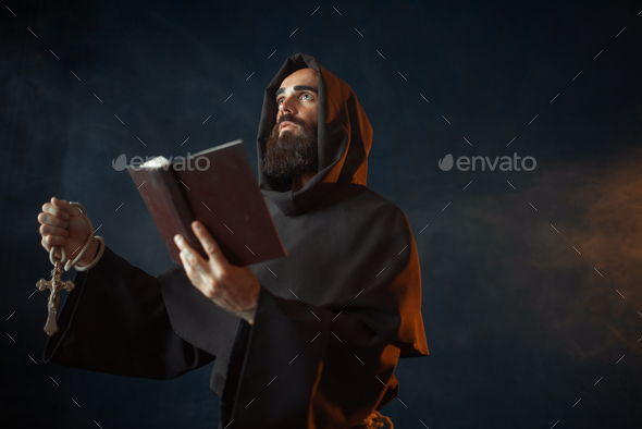 Medieval monk with spellbook calling the spirits - Stock Photo - Images