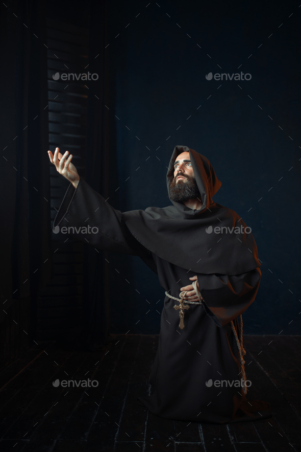Medieval monk kneeling and praying, religion - Stock Photo - Images