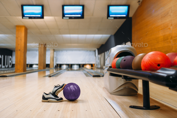 Bowling ball and house shoes on wooden floor