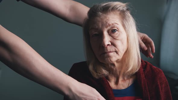 Young Man Covering Elderly Woman with Blanket in the Nursing Home alt