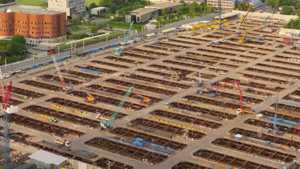 Time lapse of aerial view of busy industrial under construction site workers working alt