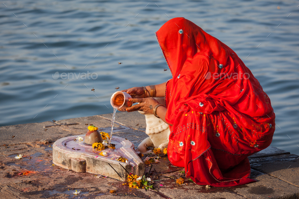 Indian woman performs morning pooja on holy river Narmada ghats - Stock Photo - Images