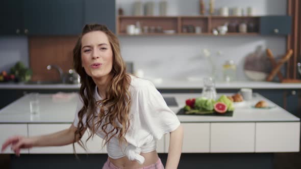 Emotional Woman Dancing on Kitchen Background, Housewife Having Fun Indoors alt